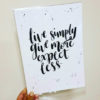 Brush calligraphy quote "Live simply, give more, expect less."