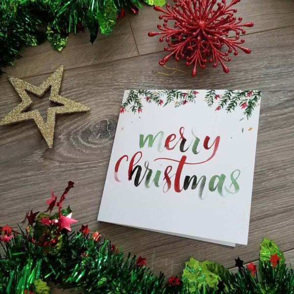 Christmas Card with 'Merry Christmas' hand-lettered in red and green underneath watercolour Australian flora. Printed on glossy 250gsm card stock Size: 14 x 14 cm Inside: blank White 14.6 x 14.6 cm envelope included