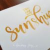 Greeting card with "You are my sunshine" hand-lettered in gold calligraphy ink. Each card is painted on matte card stock. Inside: blank. © Joy Adan 2018